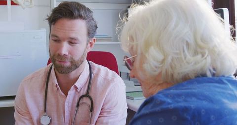 Doctor Consulting Senior Patient with Tablet in Retirement Home