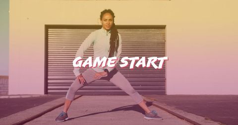 Fit woman stretching outdoors with inspiring 'game start' text