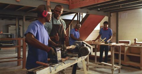 Instructor Mentoring Trainees in Woodworking Workshop