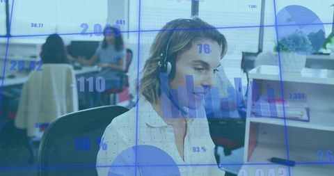 Female support agent with headset analyzing digital data in office