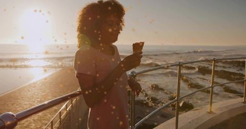 Woman Enjoying Ice Cream During Serene Coastal Sunset