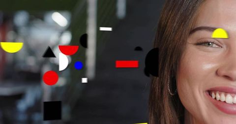 Smiling indian woman showing teeth with colorful geometric overlays and bokeh background