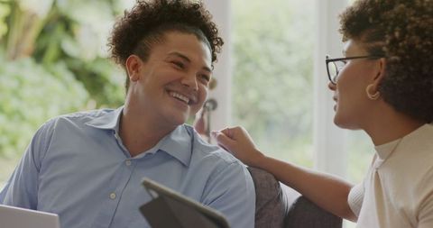 Couple Enjoying Technology at Home Smiling in Warm Conversation