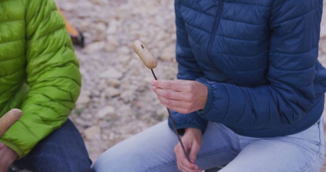 Friends Roasting Marshmallows Outdoors in Winter Jackets - Download Free Stock Images Pikwizard.com