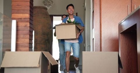 Happy Young Couple Moving into New Home with Boxes