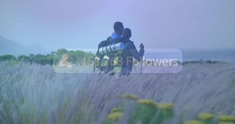Couple hiking toward ocean on misty coastal meadow with social media followers overlay
