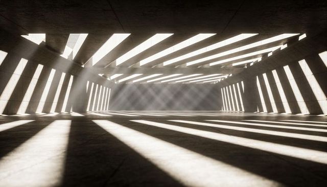 Sunlit concrete hall with parallel light shafts, slatted beams and atmospheric haze