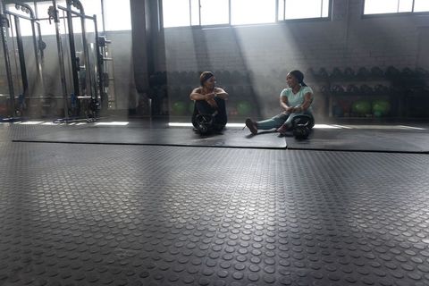 African american women resting after kettlebell workout in sunlit urban gym studio