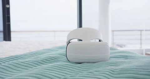 Virtual Reality Headset on Blue Blanket Next to Balcony