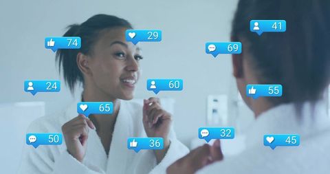 Smiling woman engaging with social media reactions in mirror while practicing self-care