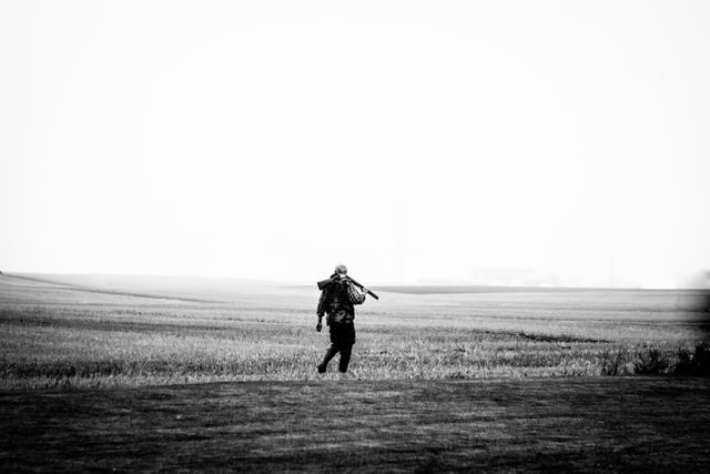 Solitary Hunter Walking in Misty Field, Black and White - Download Free Stock Photos Pikwizard.com