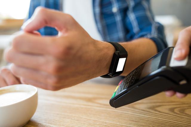 Man using smart watch for express pay at table