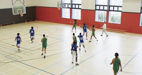Basketball Teams Competing With Coach Inside Sports Hall