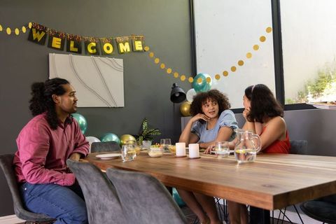 Diverse friends gathering at home party with decor and banner