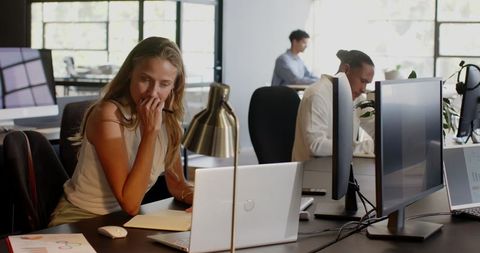 Businesswoman Taking Notes at Desk in Modern Office