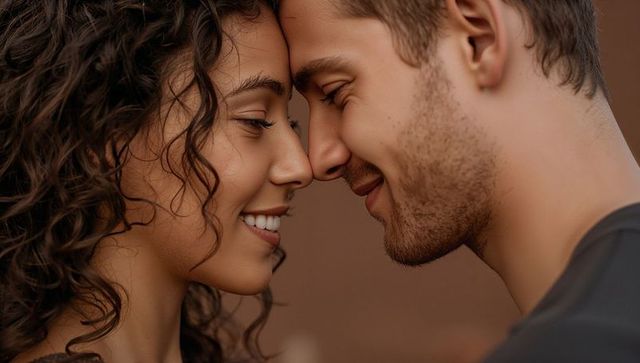 Intimate couple pressing foreheads smiling close-up conveying tender warmth and connection