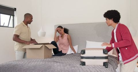 Family packing together for a vacation in bedroom