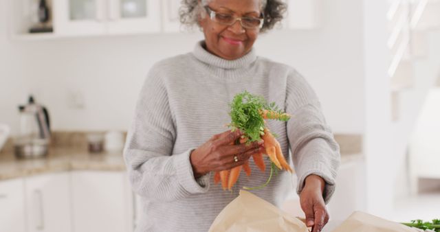 Elderly Woman Preparing Fresh Carrots in Modern Kitchen - Download Free Stock Images Pikwizard.com