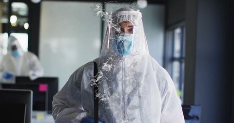 Healthcare Worker Wearing Full PPE Standing in Office with Cracked Glass Graphic for Contamination