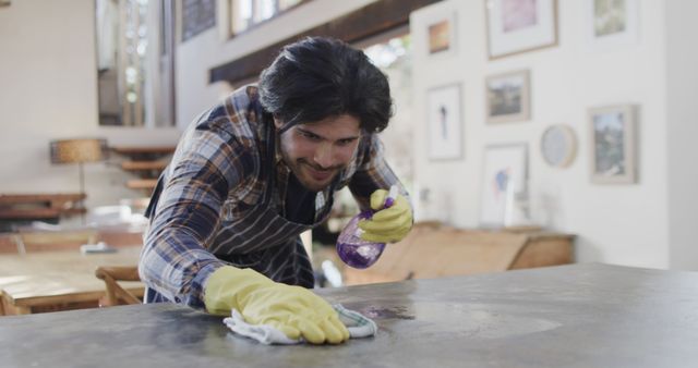 Young Man Cleaning Countertop with Spray Bottle and Gloves at Home - Download Free Stock Images Pikwizard.com