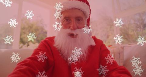 Festive Man in Santa Costume with Falling Snowflakes on Video Call