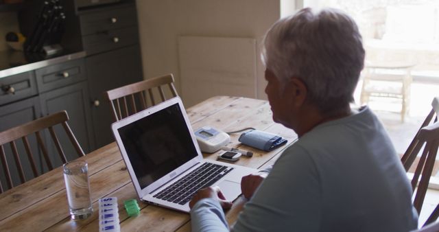 Senior Woman Using Laptop in Kitchen with Medication Organizer - Download Free Stock Images Pikwizard.com