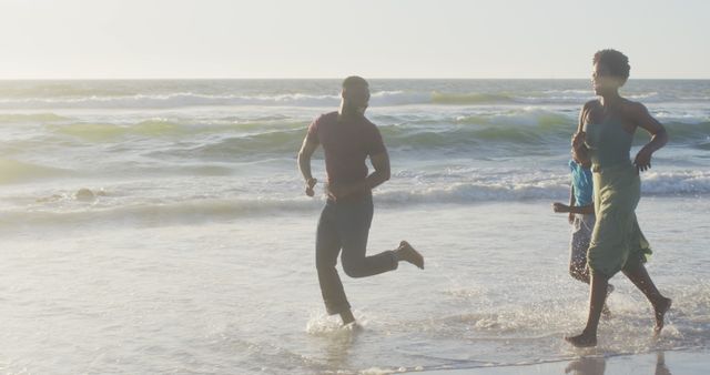 Joyful Family Running on Beach at Sunset - Download Free Stock Images Pikwizard.com