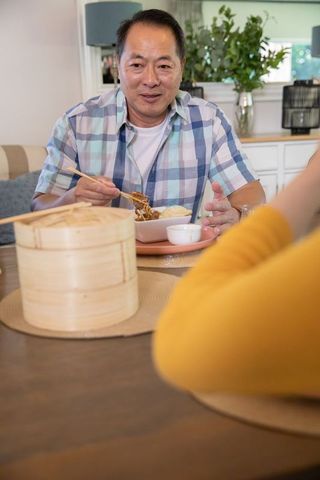 Family Enjoying Traditional Meal with Noodles and Bamboo Steamers