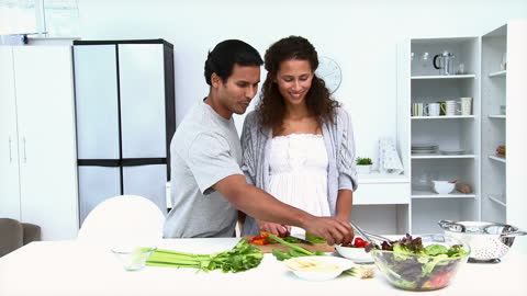 Couple Embracing While Preparing Meal in Bright Modern Kitchen