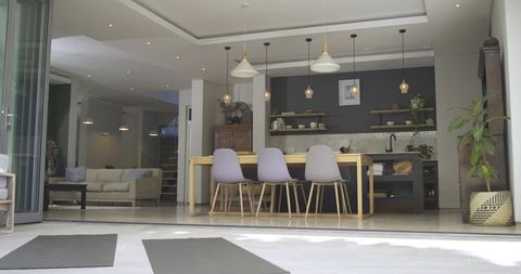 Modern Open-Plan Interior with Wooden Dining Table and Pastel Chairs