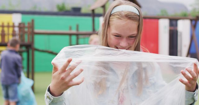 Girl Enjoying Playtime with Plastic Sheet Outdoors - Download Free Stock Images Pikwizard.com