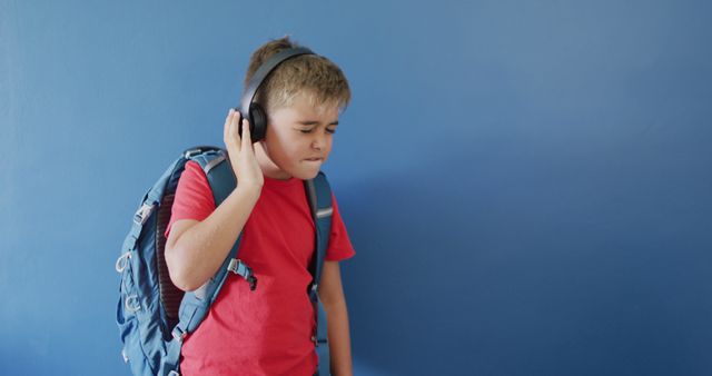 Young Boy with Backpack Listening to Music with Headphones - Download Free Stock Images Pikwizard.com