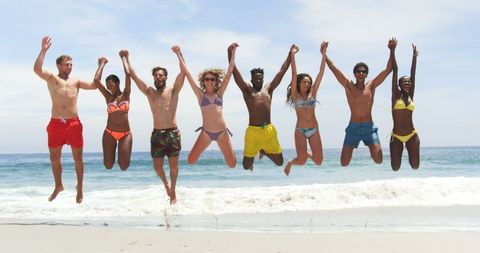 Diverse Friends Jumping Joyfully at Beach
