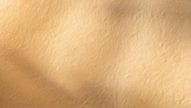 Textured Vintage Parchment Background with Warm Beige Grain and Subtle Creases