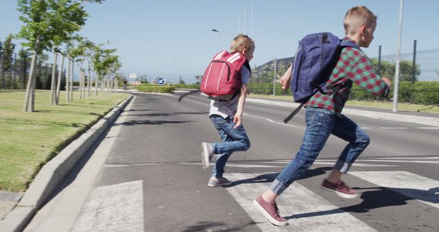 Two Schoolboys Running Across a Crosswalk with Backpacks on a Sunny Day - Download Free Stock Images Pikwizard.com