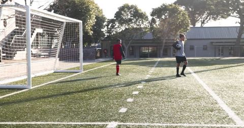 Young Soccer Goalkeeper Practicing on Sunlit Field