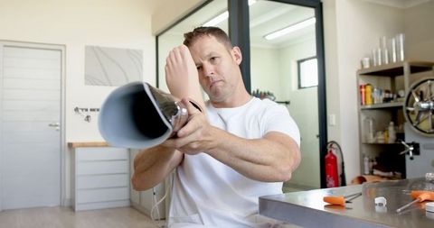 Technician adjusting below-knee prosthetic leg in workshop
