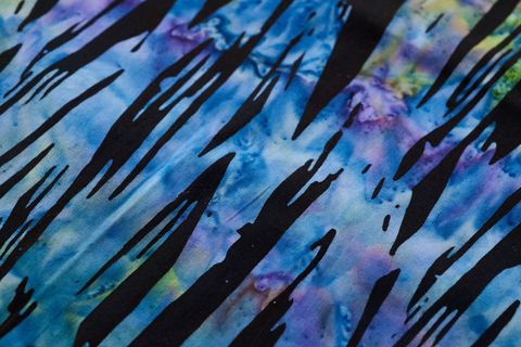 Abstract blue tie-dye textile featuring black brush stroke pattern for design