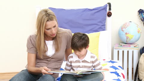 Mother Reading Storybook with Son in Cozy Bedroom