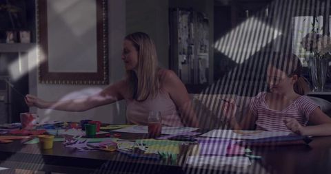 Family crafts session cutting and painting at home dining table