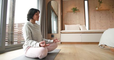 Woman Practicing Meditation in Cozy Bright Living Space
