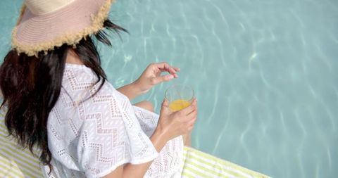 Teenage Girl in Sun Hat Enjoying Relaxing Poolside Moment