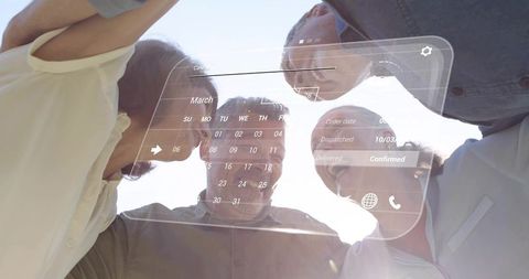 Four professionals leaning together checking holographic calendar and order dashboard
