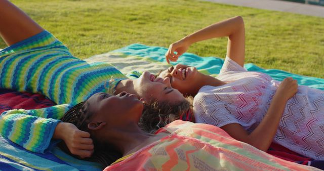 Three Young Women Relaxing on Colorful Blankets on Grass - Download Free Stock Images Pikwizard.com