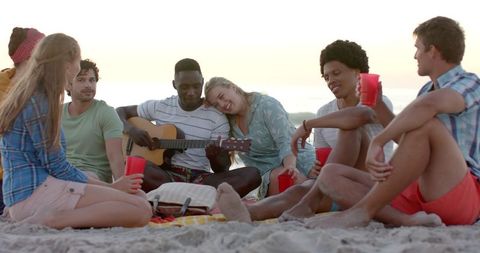 Diverse Friends Enjoy Sunset Music on Beach