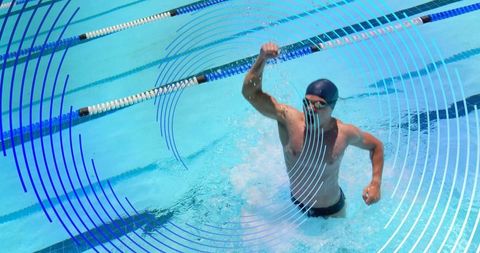 Victorious swimmer rising through water with blue graphic rings and sunlit pool