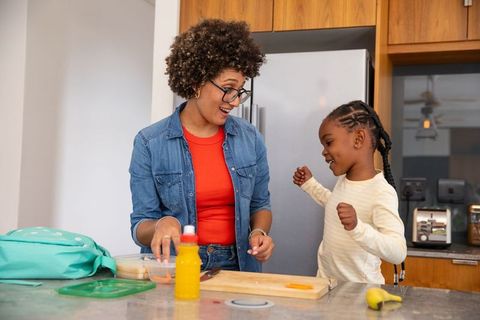 Mother and Daughter Preparing Snacks in a Modern Kitchen