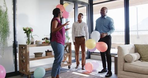 Colleagues preparing office for celebration with balloons