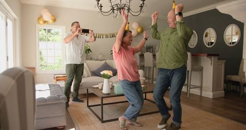 Excited Seniors Joyfully Dancing at Home Birthday Celebration