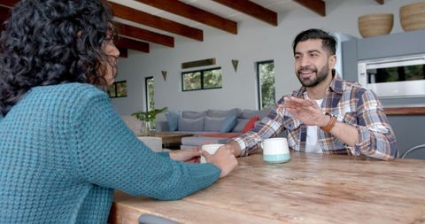 Young Asian Man Engaged in Serious Conversation at Home Kitchen